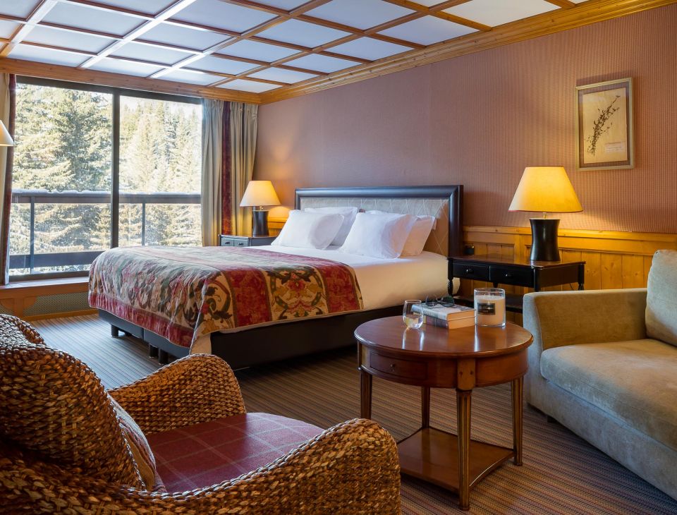 lit double avec deux fauteuils et une petite table-hotel courchevel luxe